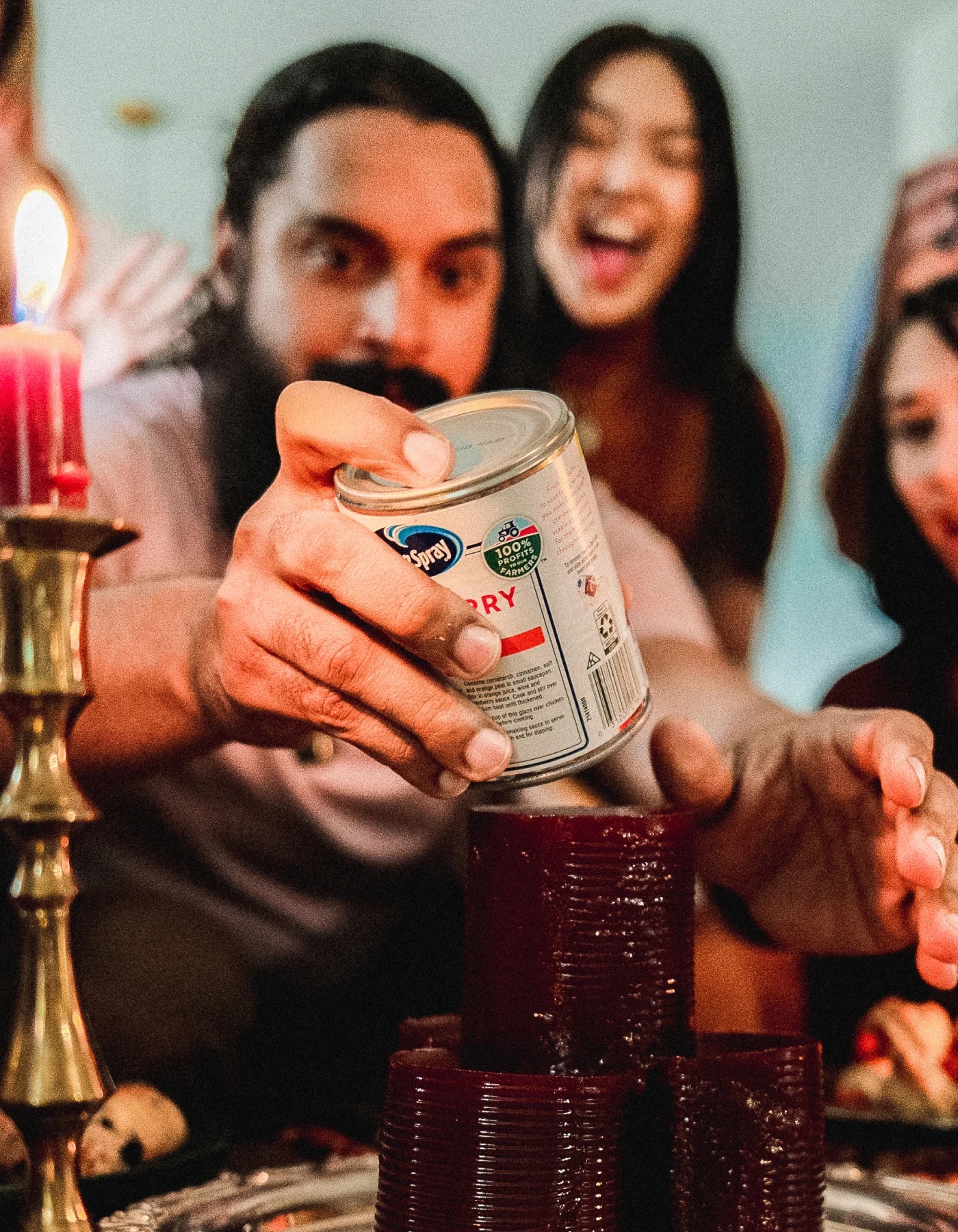 A group of people stacking canned cranberry sauce.